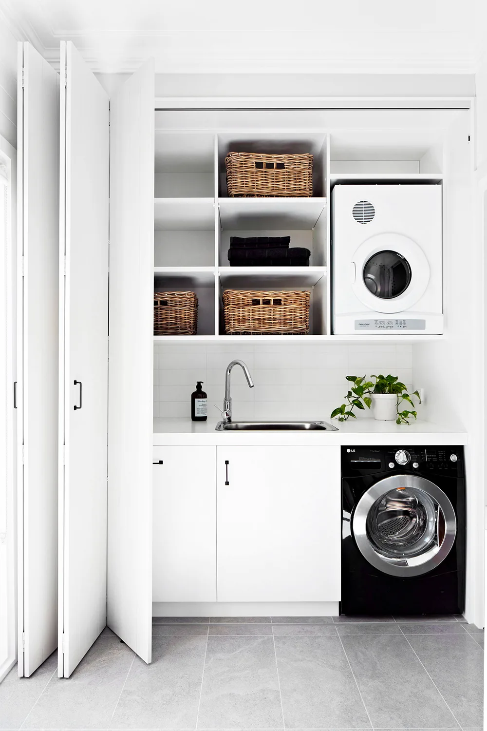 white laundry in cupboard with bifold doors