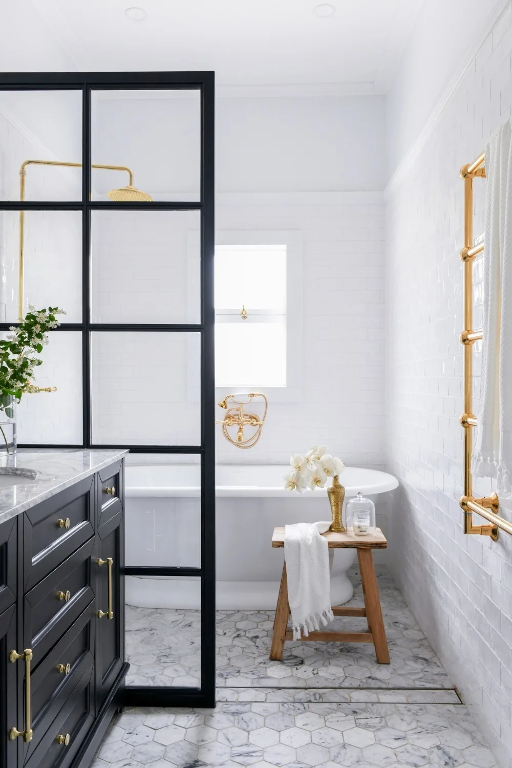 Modern black and white bathroom with hexagonal marble floor tiles and gold hardware