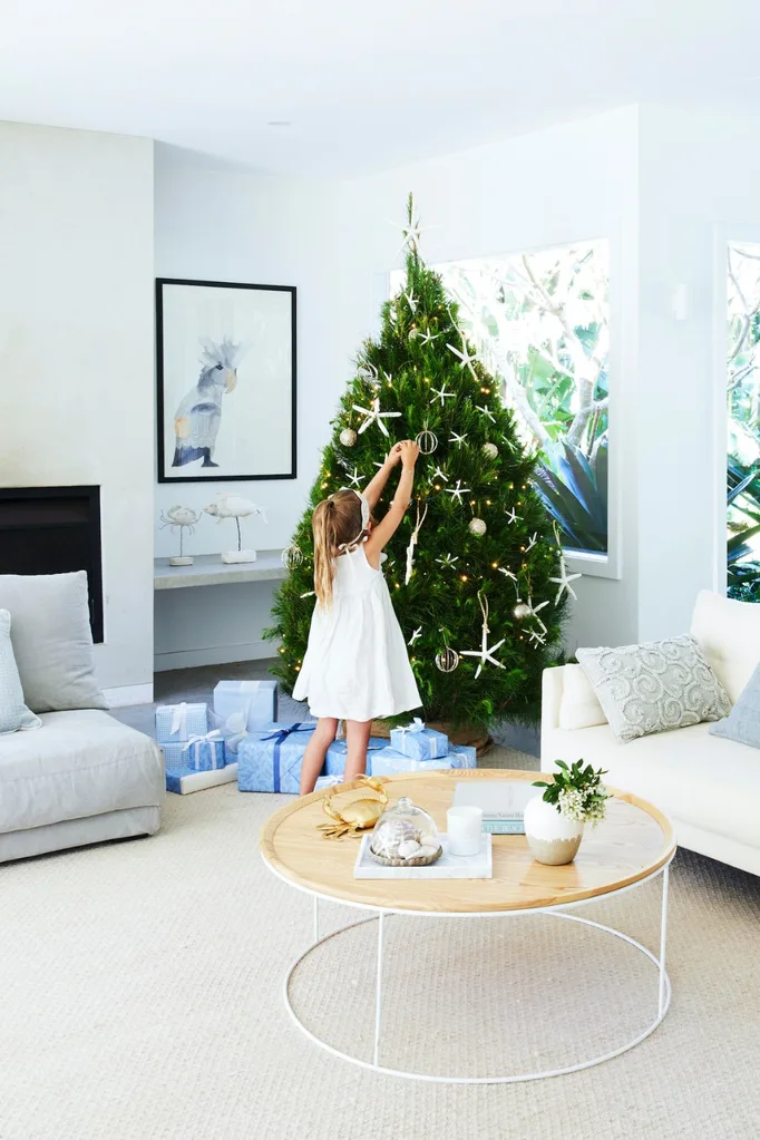 Girl decorating a coastal style Christmas tree