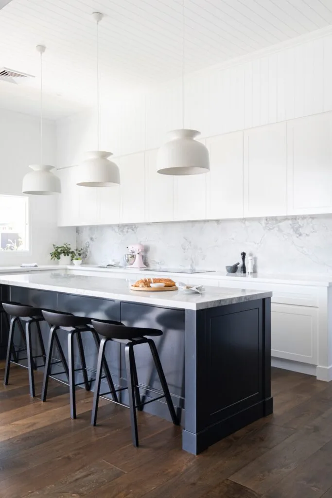 Minimalist black and white marble kitchen with white bell pendants