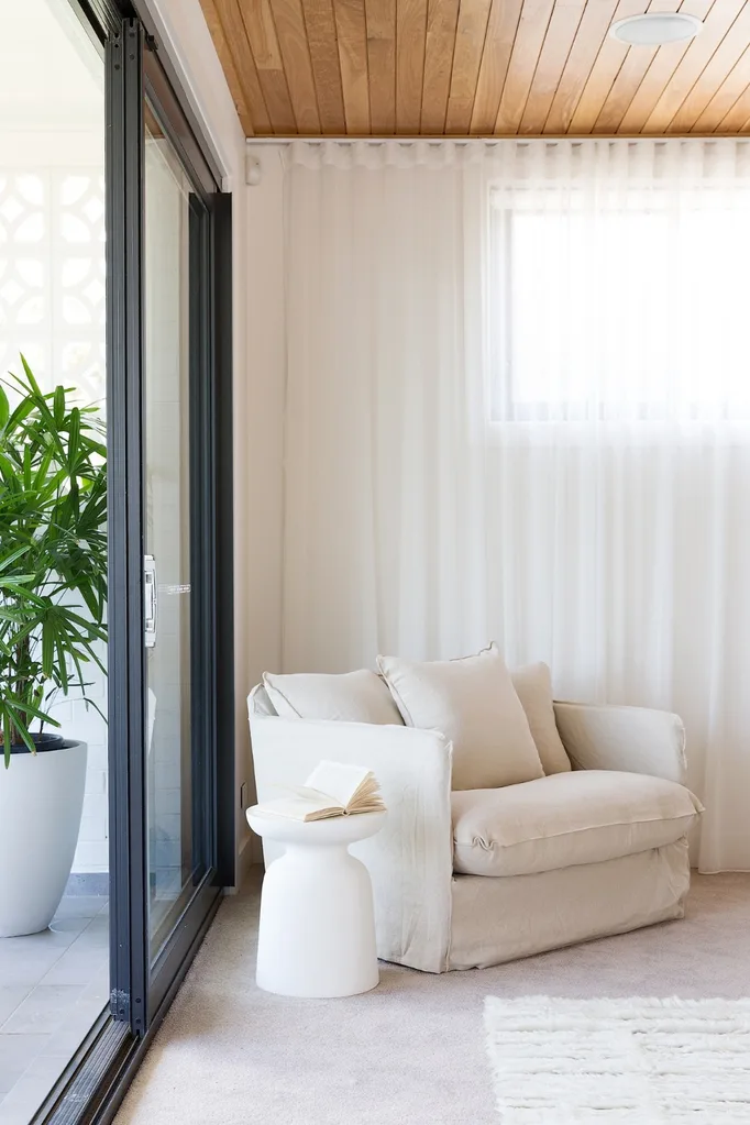 White linen armchair in the corner of a living room