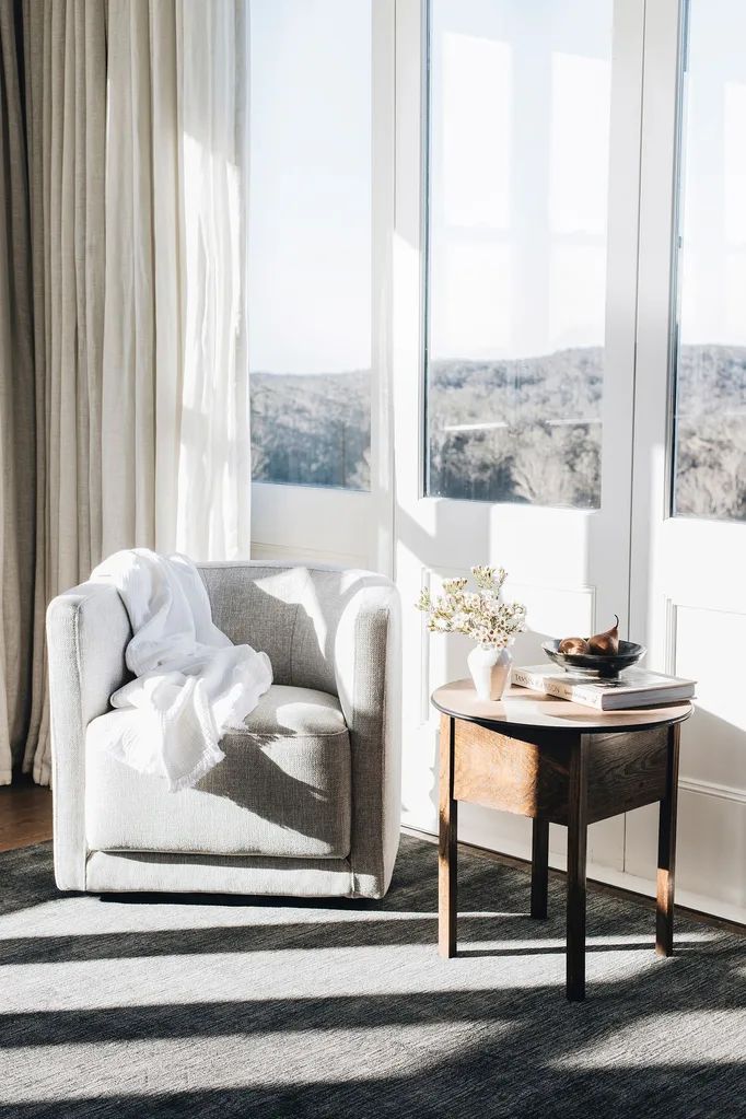 tub chair with sheer curtains by window in living room