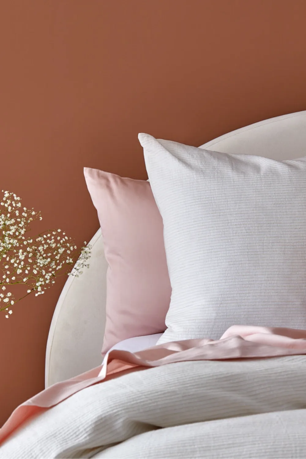 terracotta wall with pink hued bedding