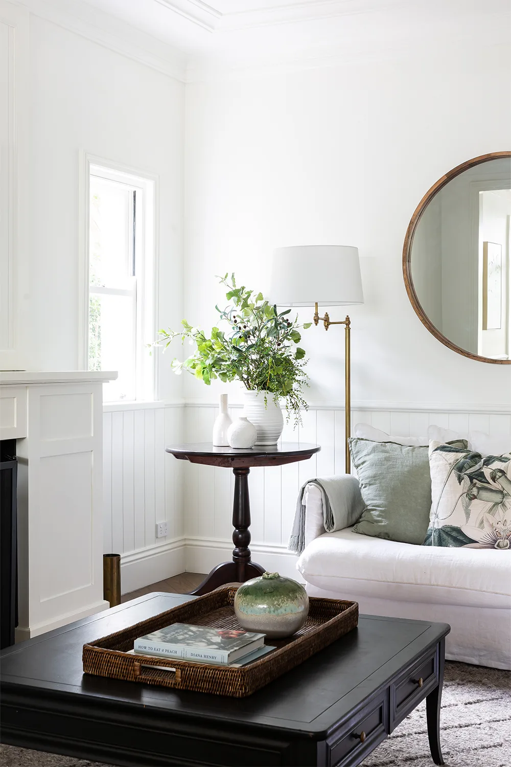 Elegant living room with white sofa and round mirror