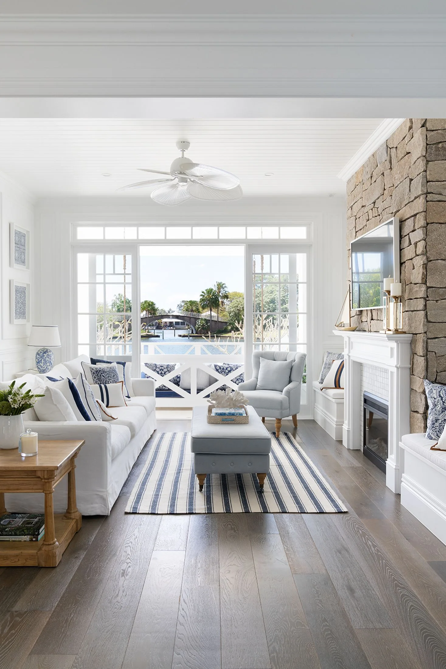 hamptons style living room with stone fireplace and water views