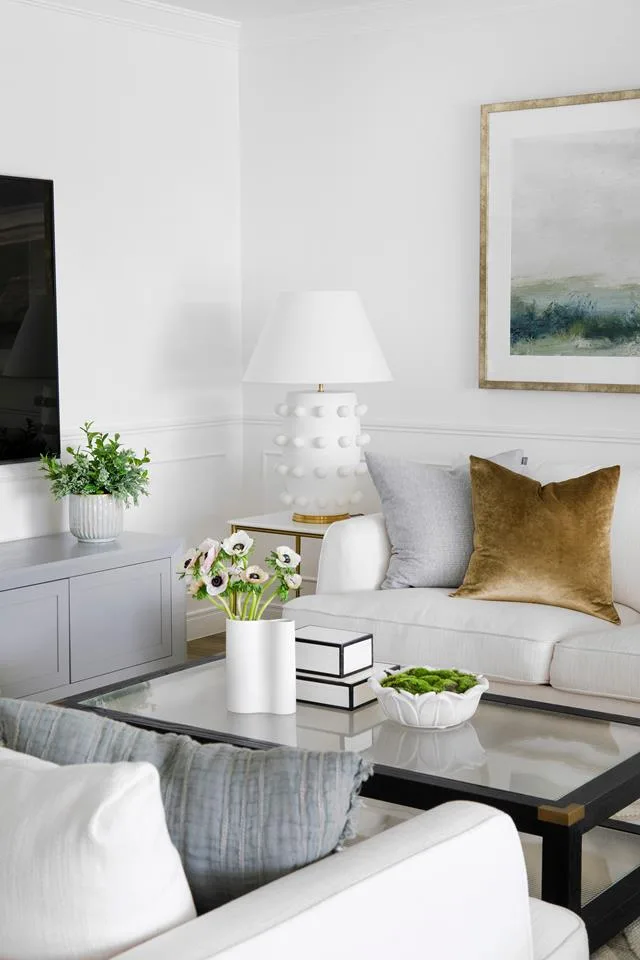 Living room with a pair of white sofas and glass and timber coffee table