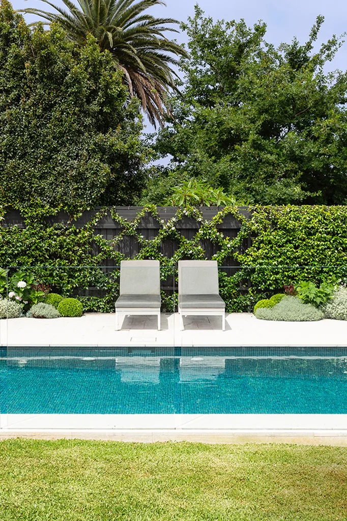 pool lounges by a landscaped garden area with pool