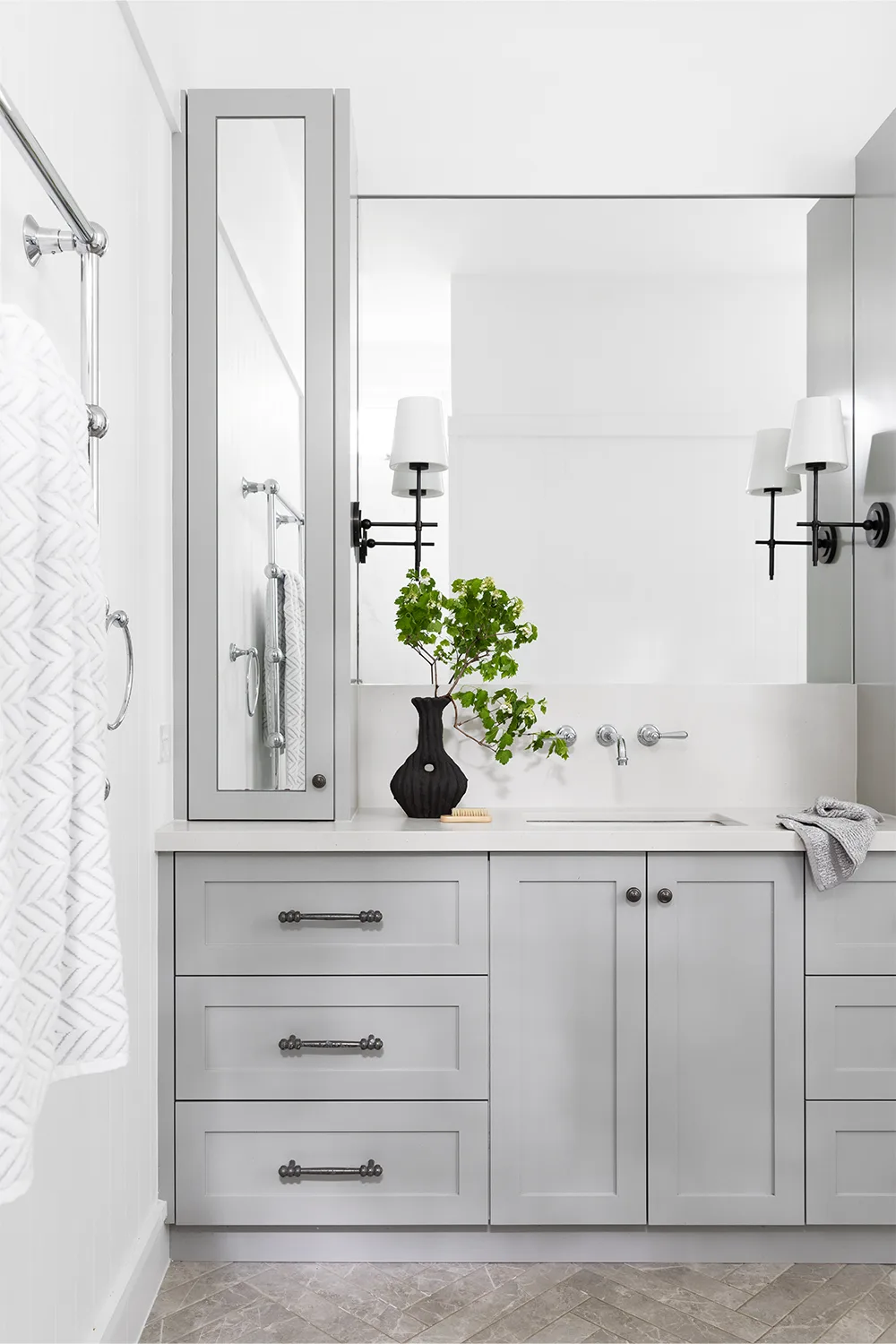 Hamptons style bathroom with wall sconces installed onto overssized mirror