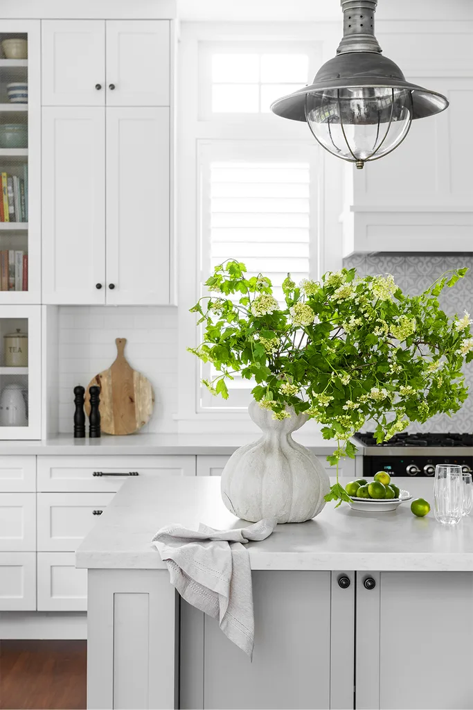 Hamptons style kitchen island with organic vase and metal lantern pendant light