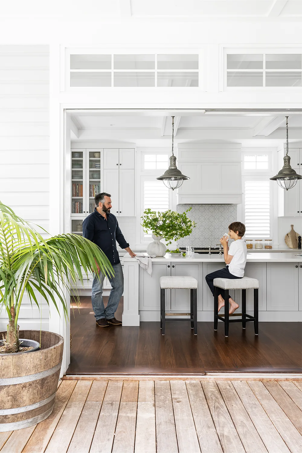 Hamptons style kitchen with bifold doors opening onto deck
