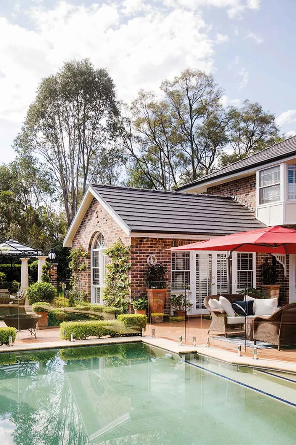 Brick Hamptons home with backyard swimming pool