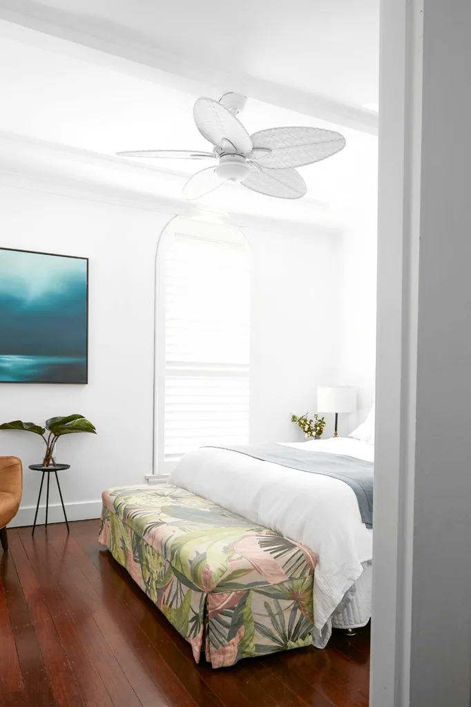 main bedroom with timber floors and arched window