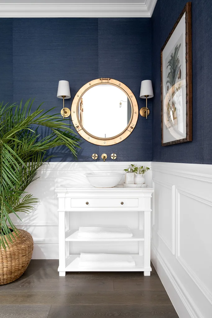 Hamptons style powder room with navy wallpaper and white wainscoting