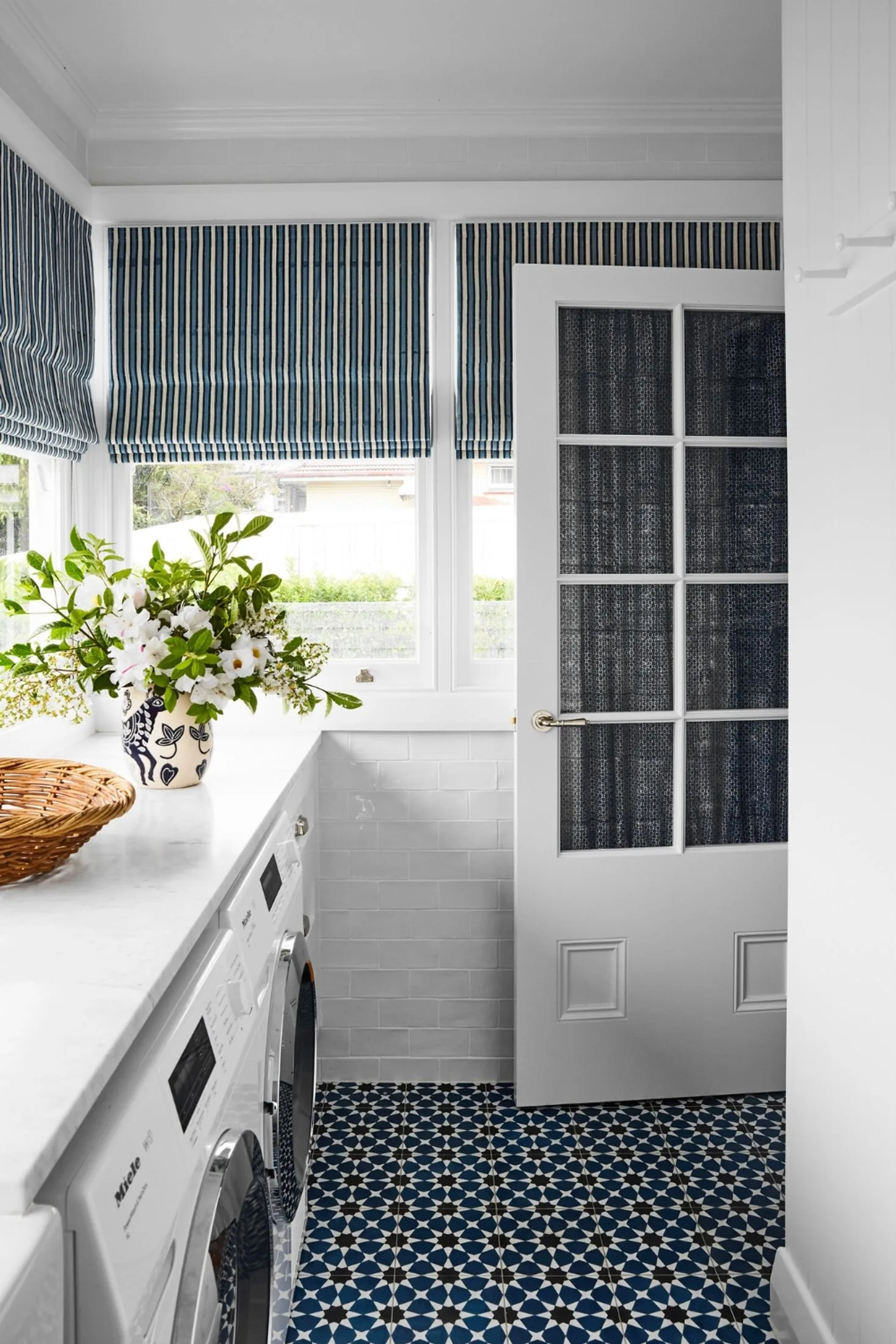 White and blue laundry with flower arrangement on bench