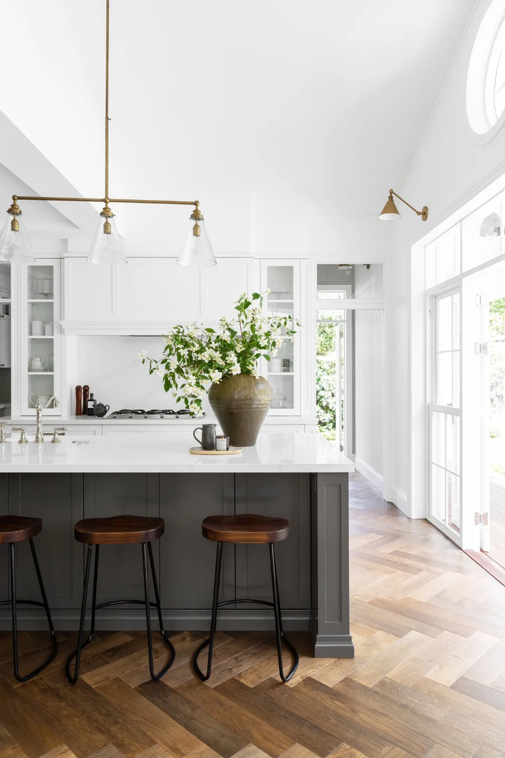 Kitchen with large flower arrangement on island bench