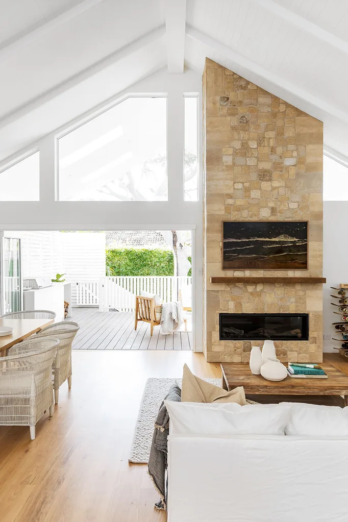 coastal style living room with floor to ceiling stone fireplace