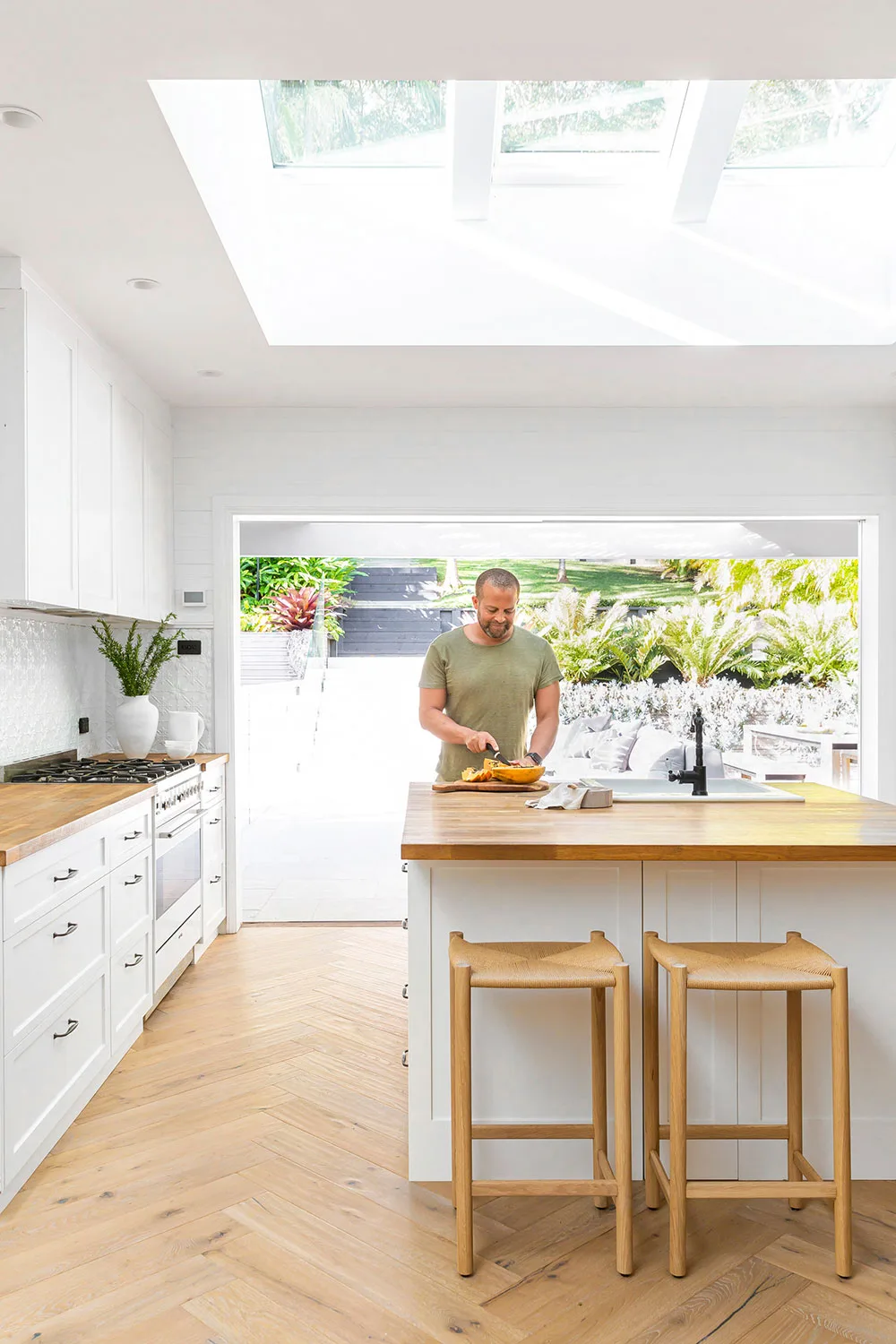 Man in coastal style kitchen cutting melon