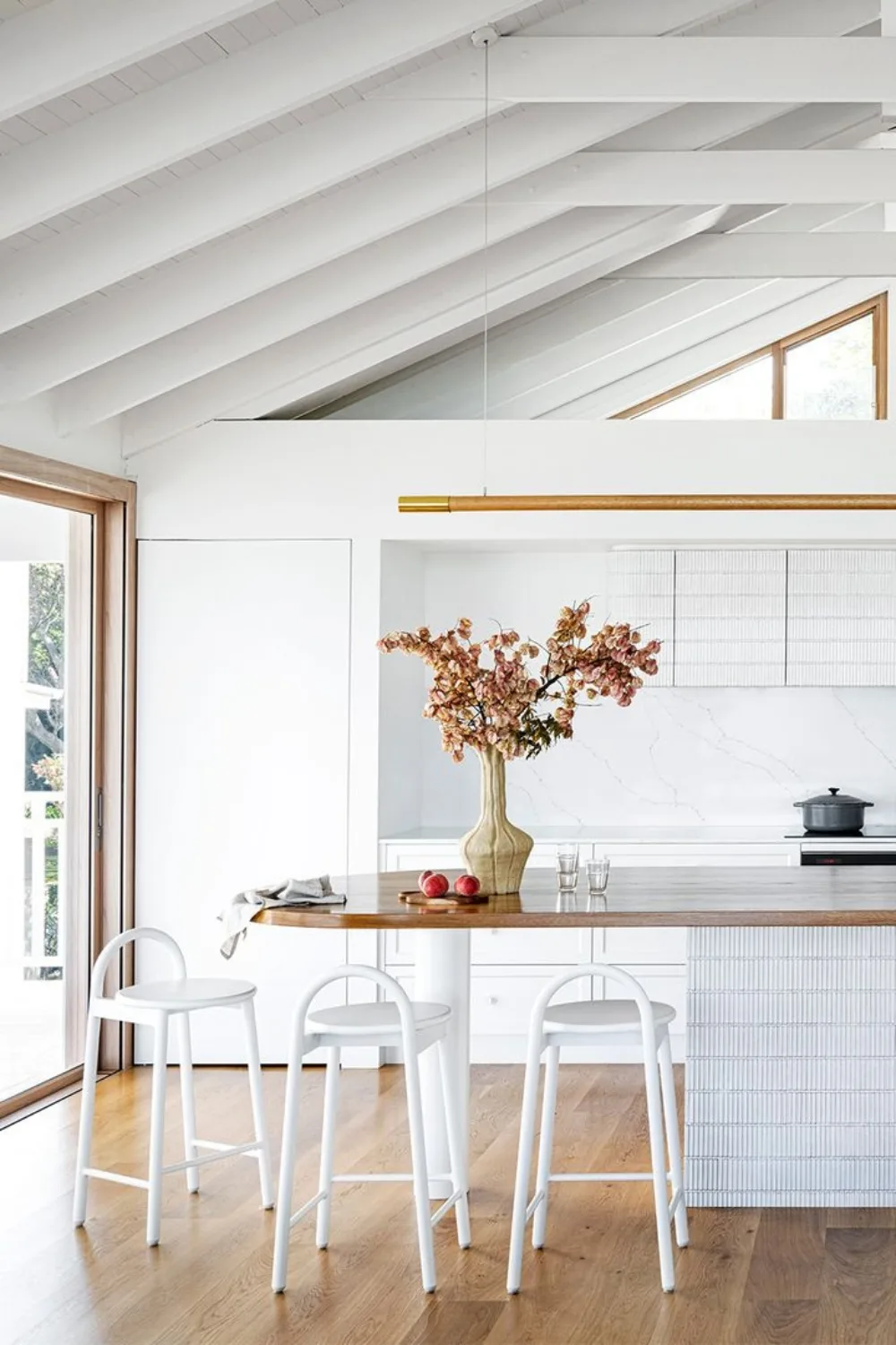 White and timber coastal kitchen with curved island bench