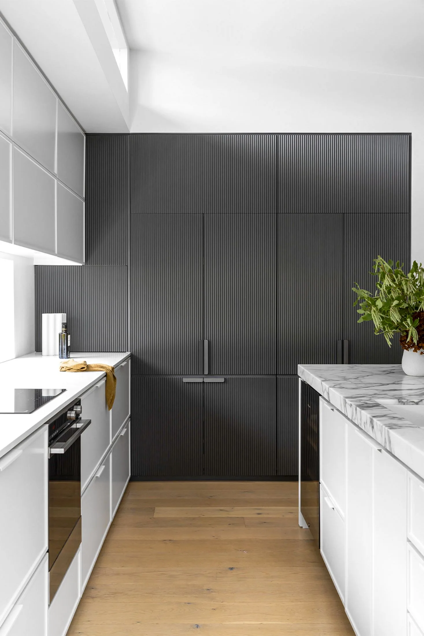 Monochrome kitchen with dark fluted cabinetry