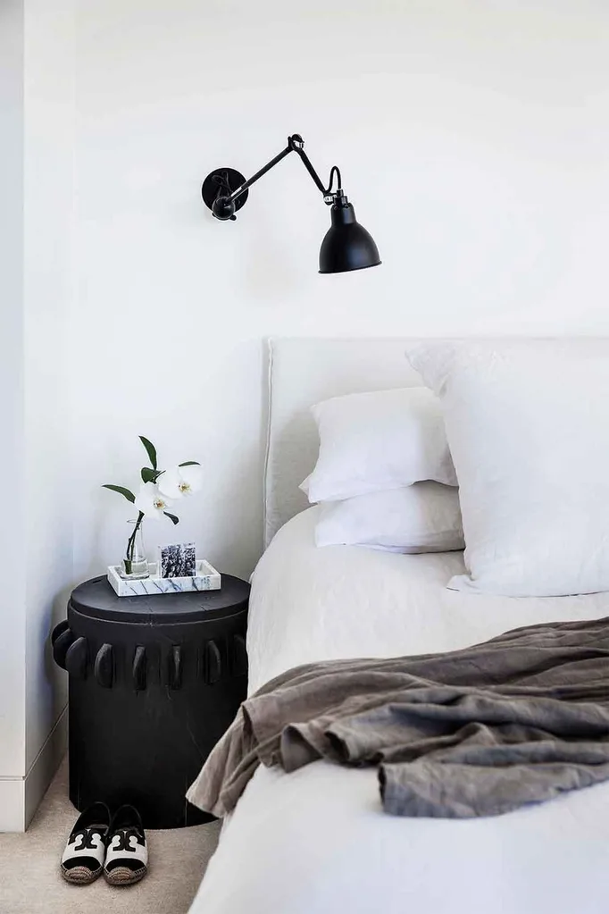 Black and white bedroom with a wall light