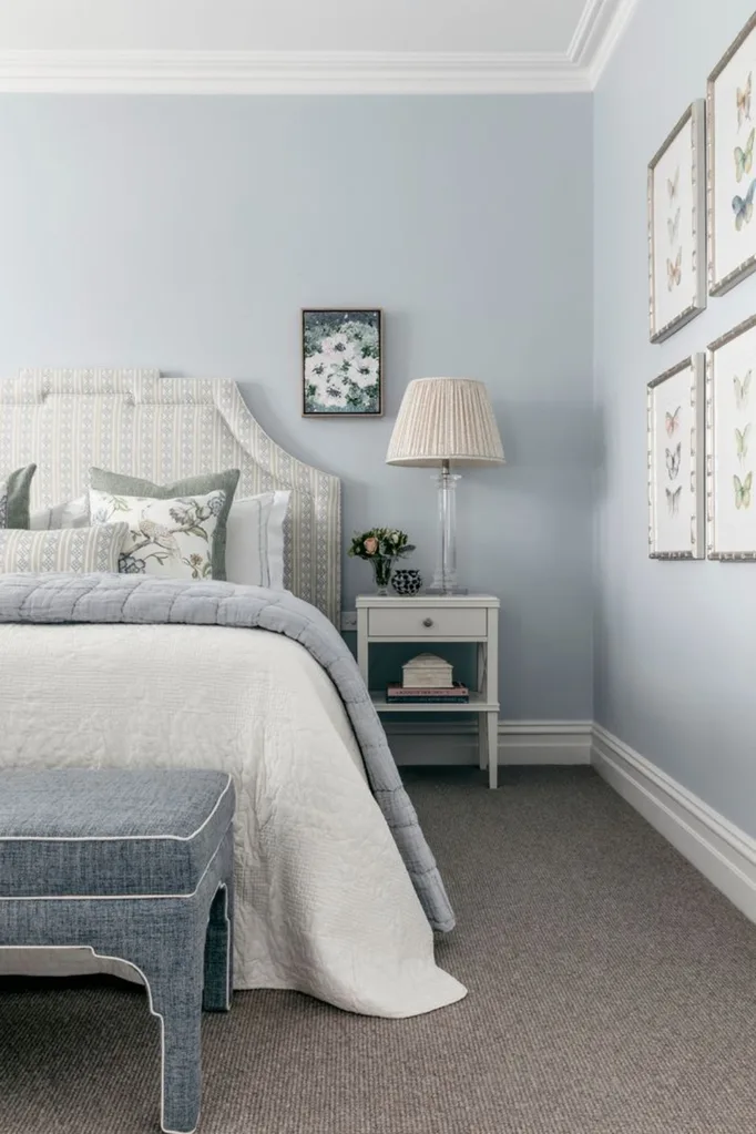 Blue Hamptons style bedroom with patterned upholstered headboard