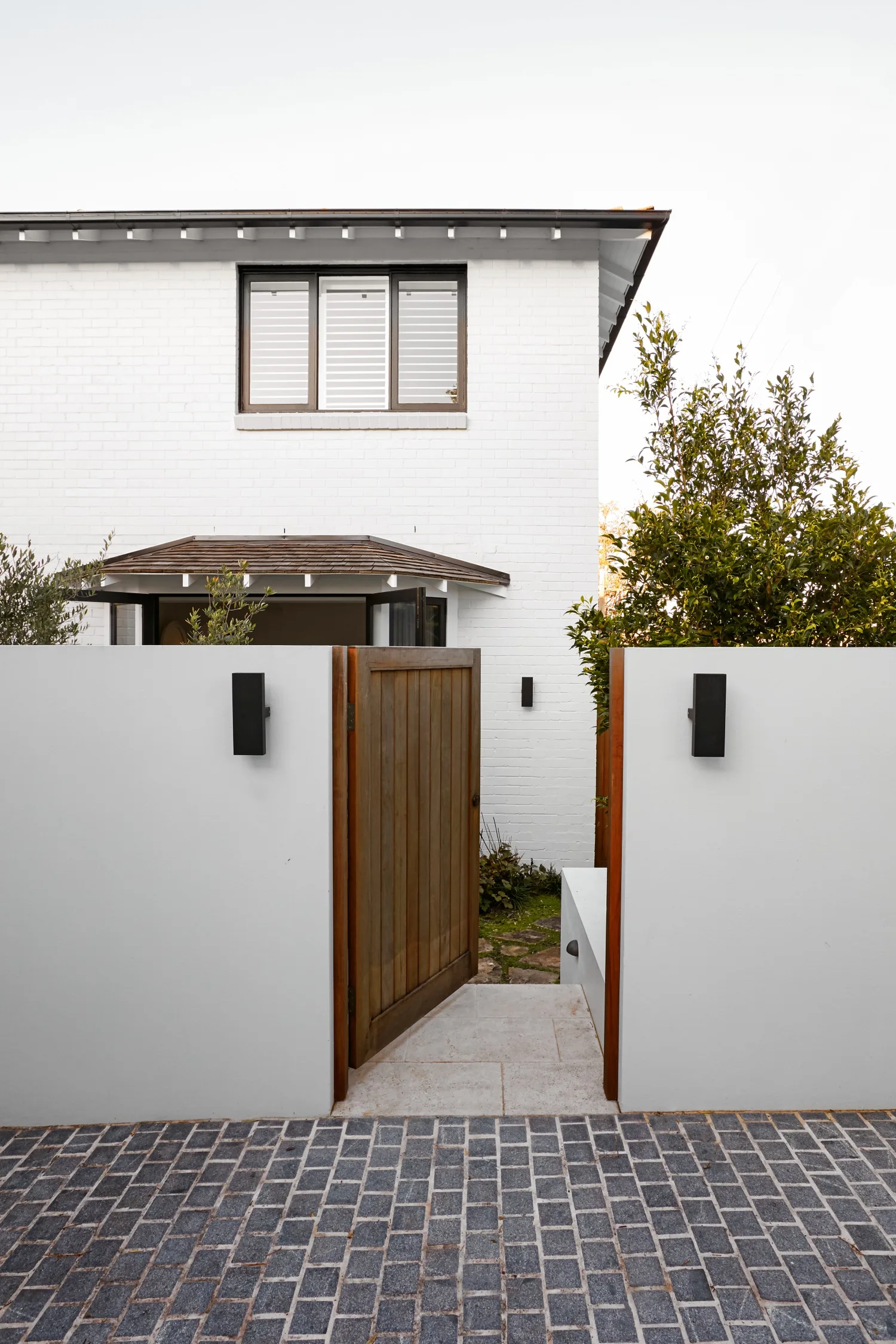 entry with wall sconces and wooden gate