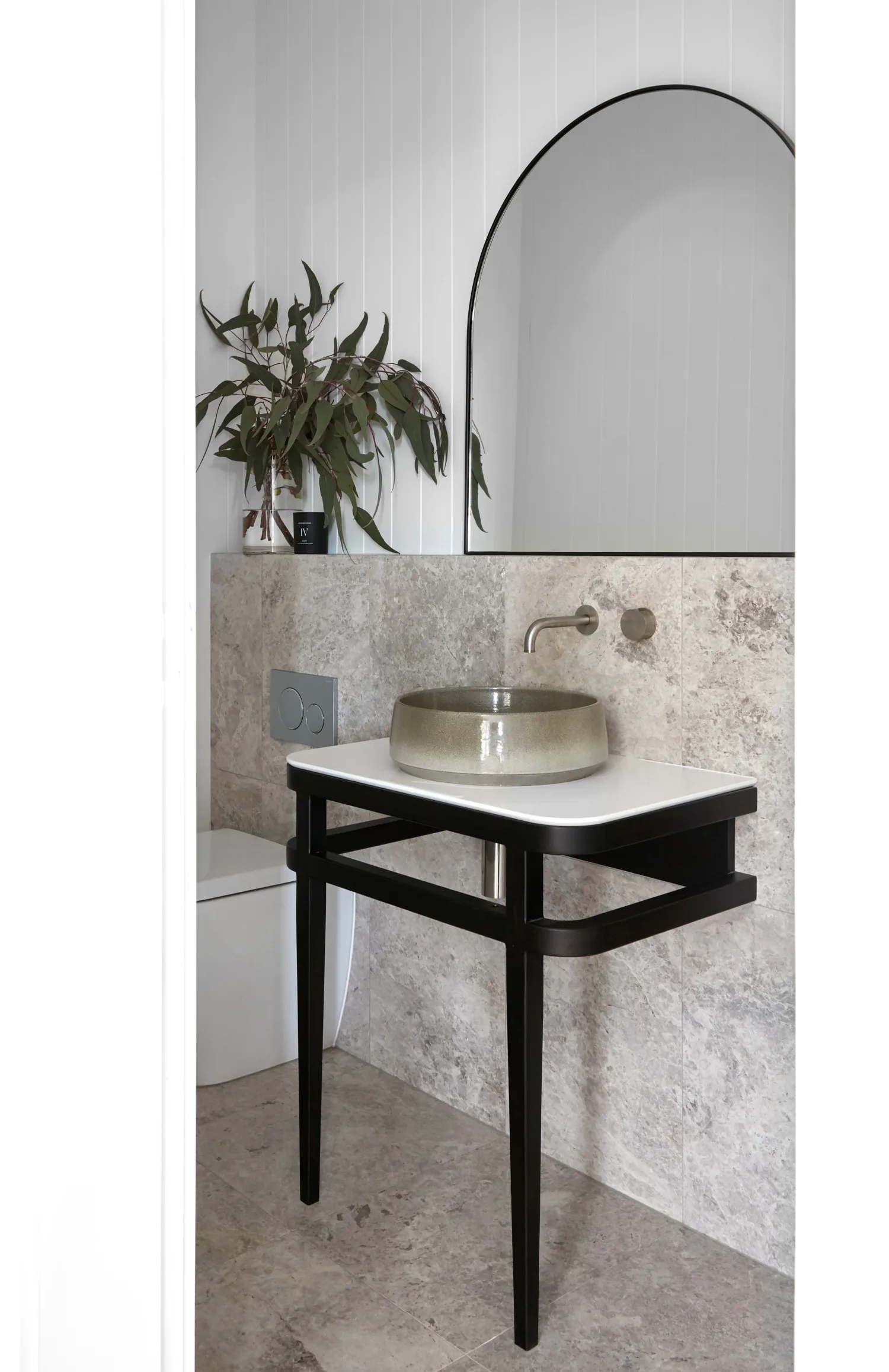 powder room with black vanity and curved mirror