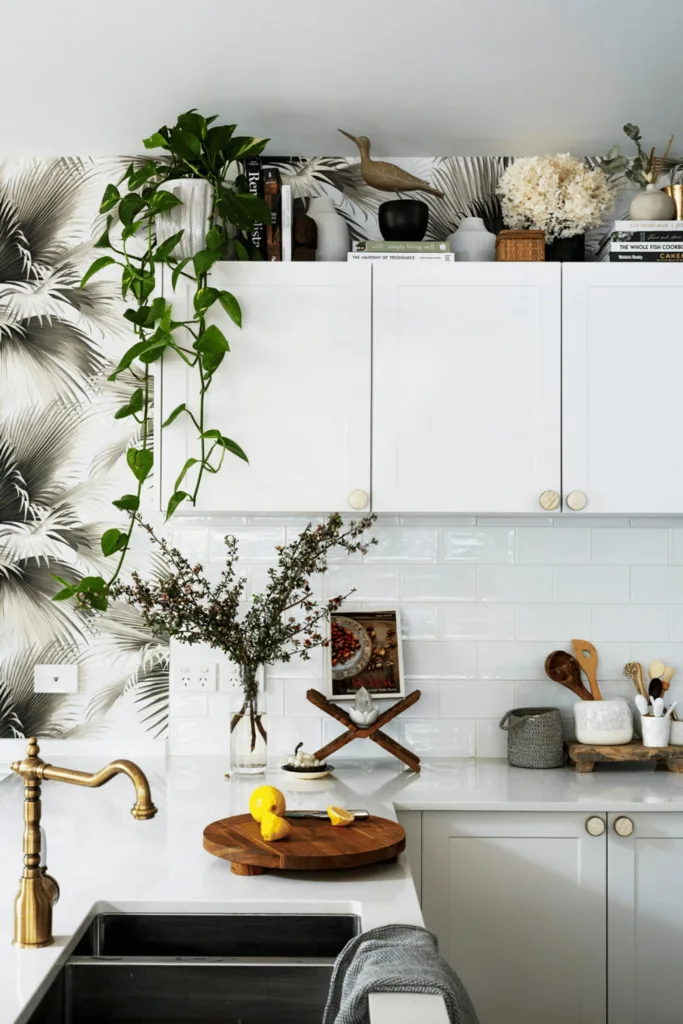 Double undermount sink in a white kitchen with house plants.