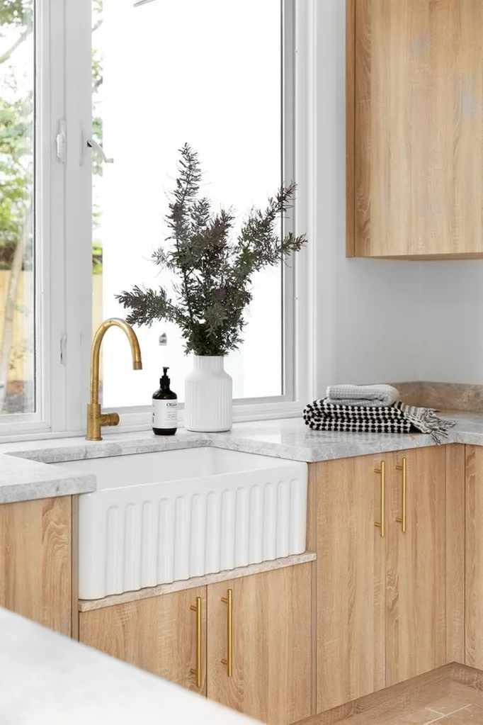 Ceramic butler's sink in timber and marble kitchen.