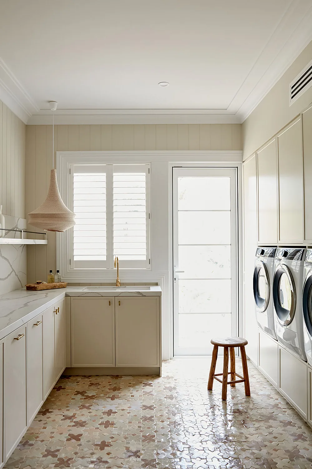 Beige, white and marble laundry by Three Birds Renovations