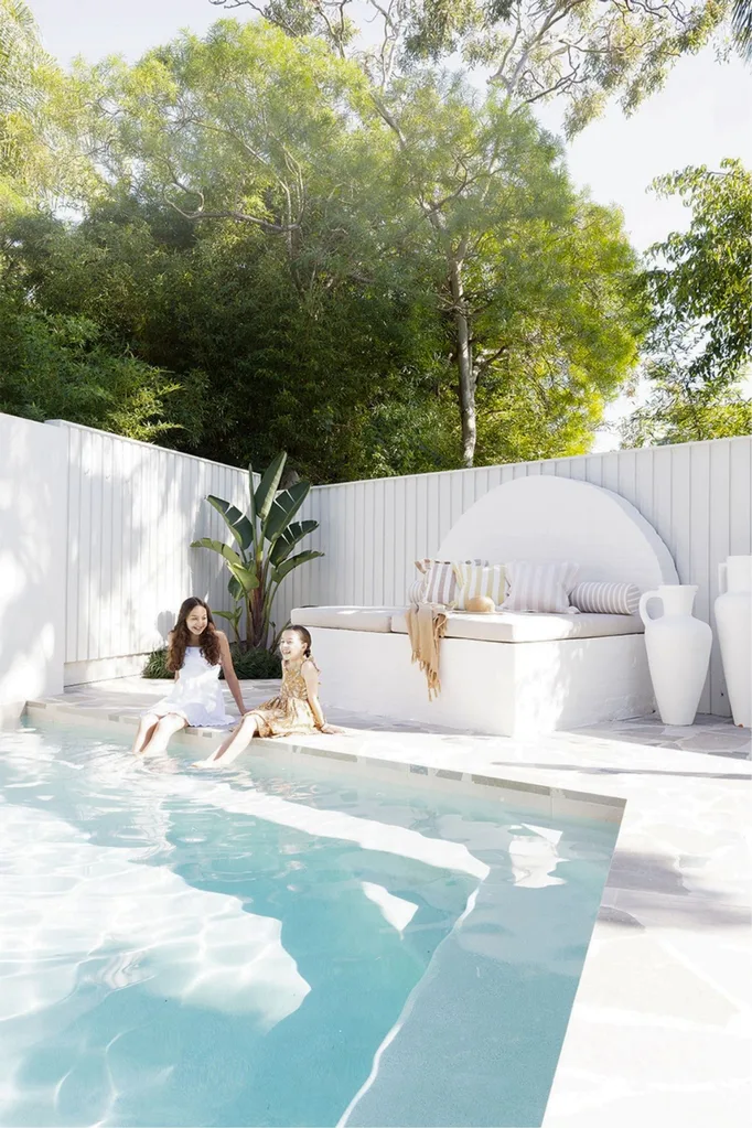 Pool deck in backyard with a day bed