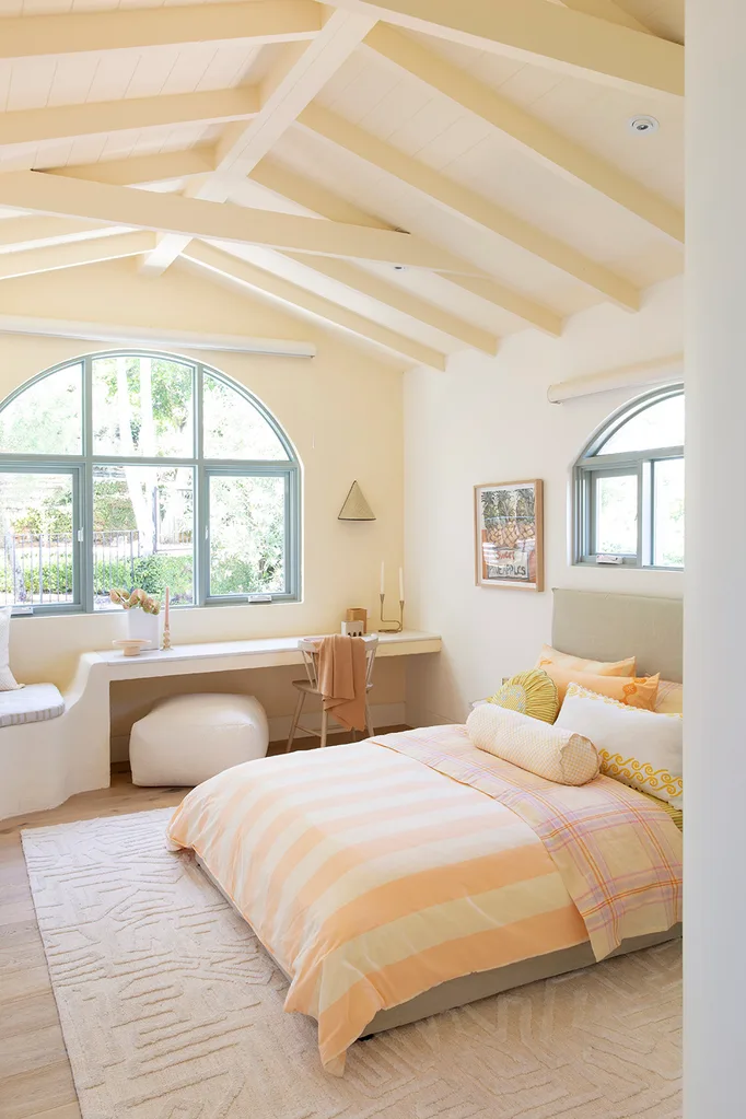 Pastel yellow teen bedroom with built-in desk and bench seat