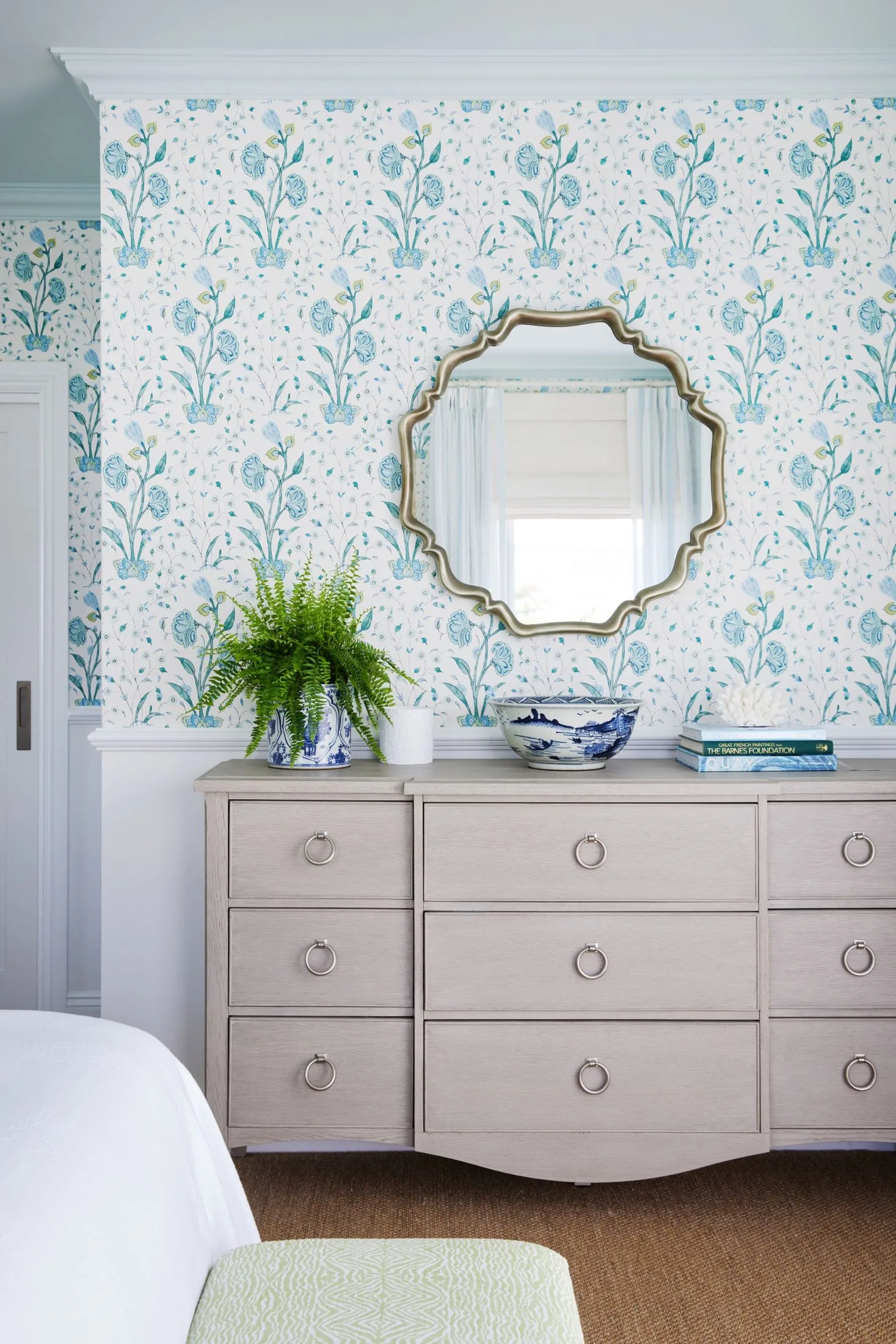 chest of drawers with light blue floral wallpaper