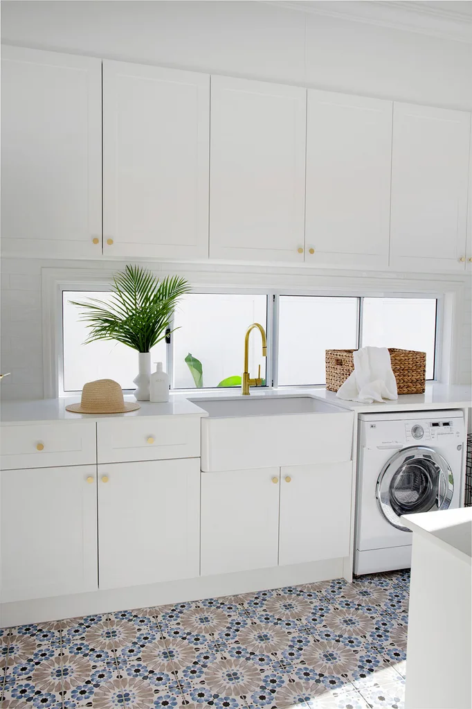 White shaker style laundry with patterned blue floor tiles