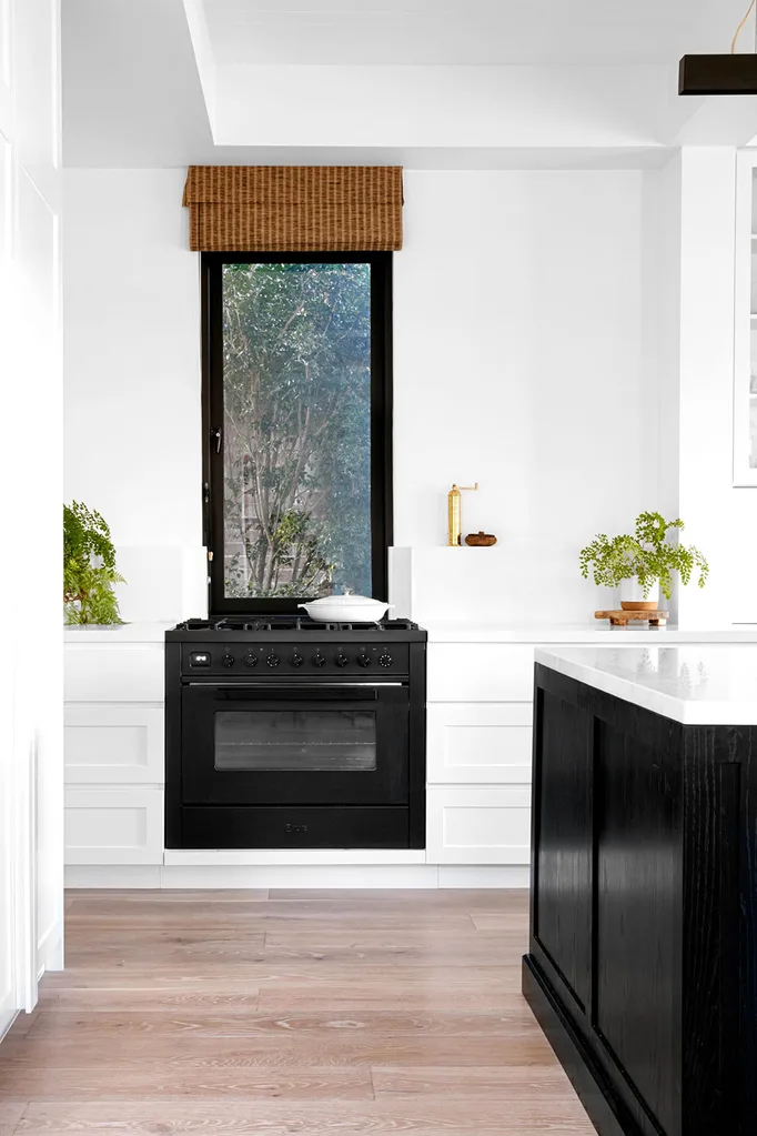 Black and white kitchen with splashback window above stove