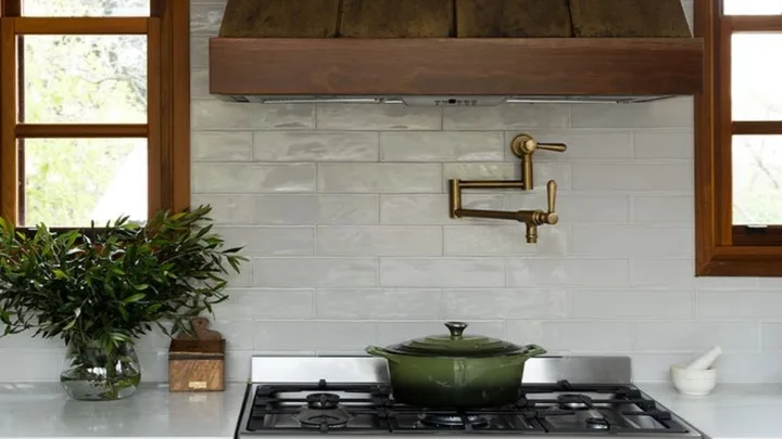 green cast iron pot on stove top with brass pot filler