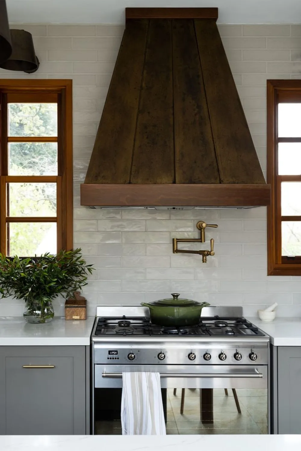 green cast iron pot on stove top with brass pot filler