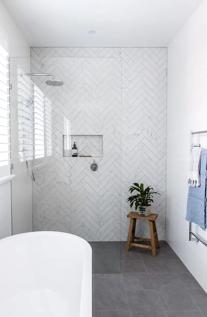 bathroom with herringbone feature wall tiles and grey floor tiles