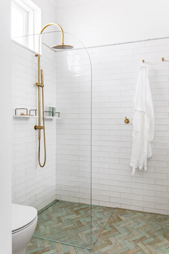 Classic coastal bathroom shower with blue herringbone floor tiles