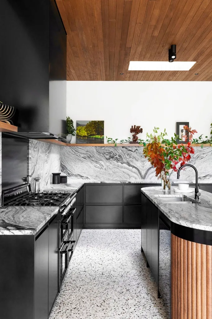 Modern black and timber kitchen with marble benchtops and terrazzo flooring