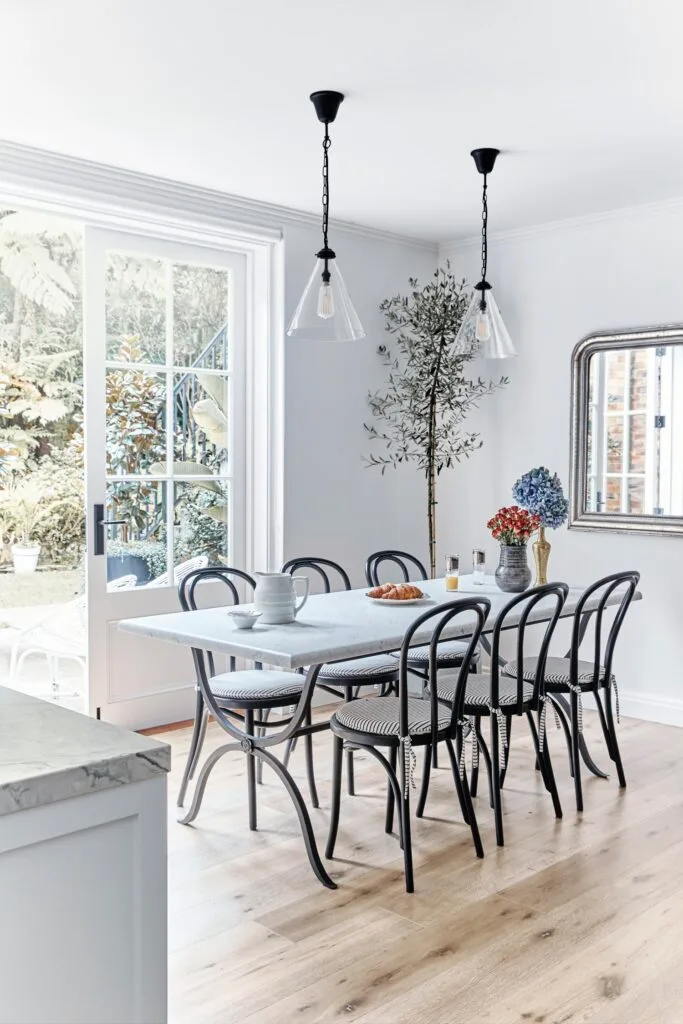 marbled dining table with bentwood chairs and olive tree