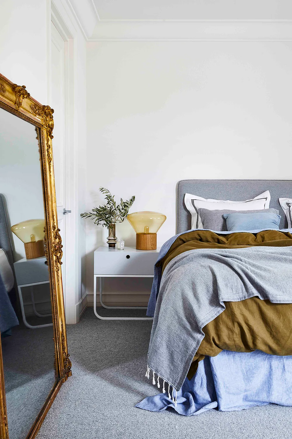 Cosy layered bed with grey, blue and khaki bedding