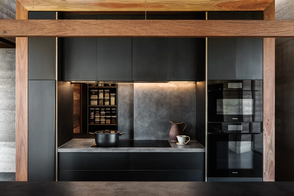 Concrete-panelled kitchen splashback slides to reveal the pantry.