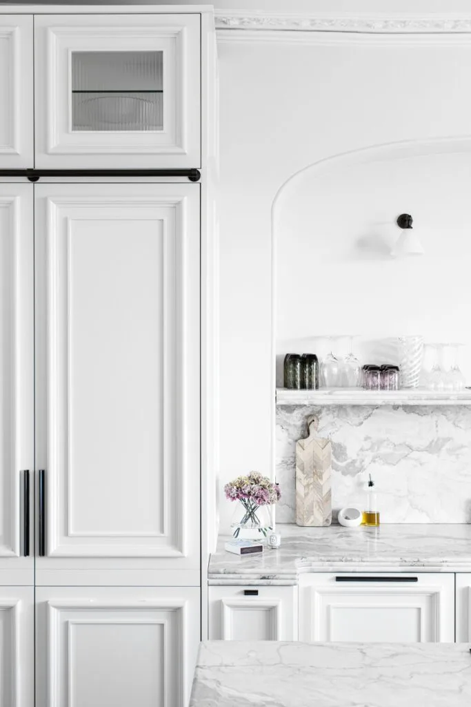 white kitchen with marble bench and black and white wall light