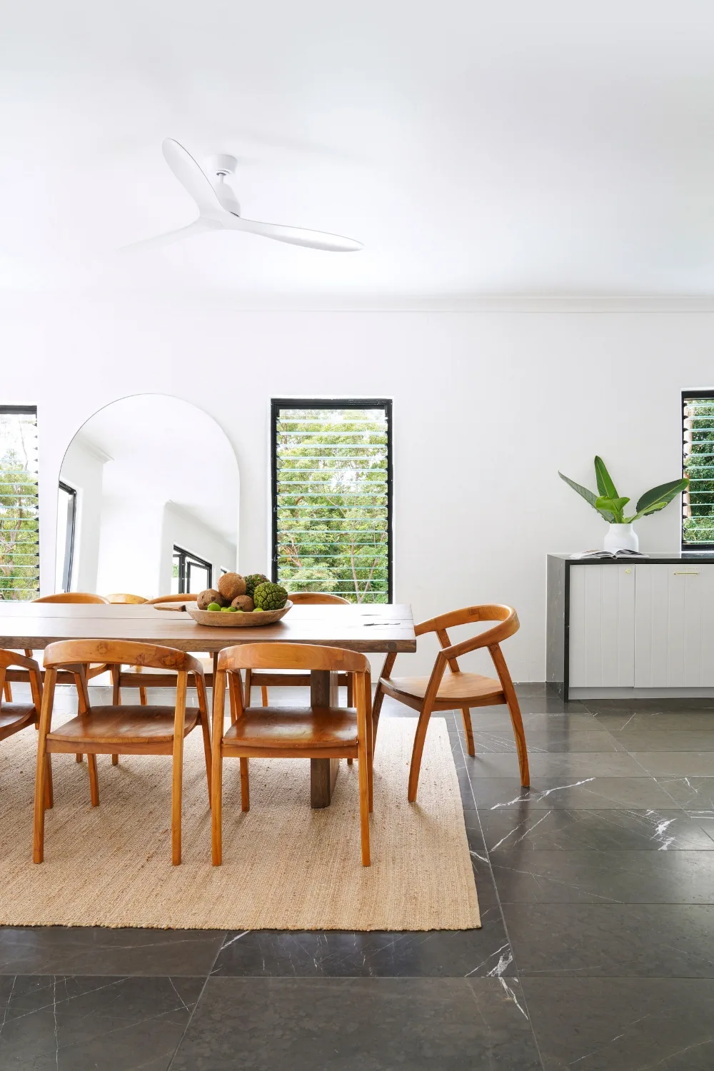 Arched floor mirror in dining room of Mediterranean-style home