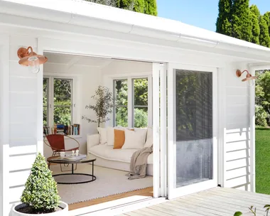 White multigenerational house with deck and gold wall lights