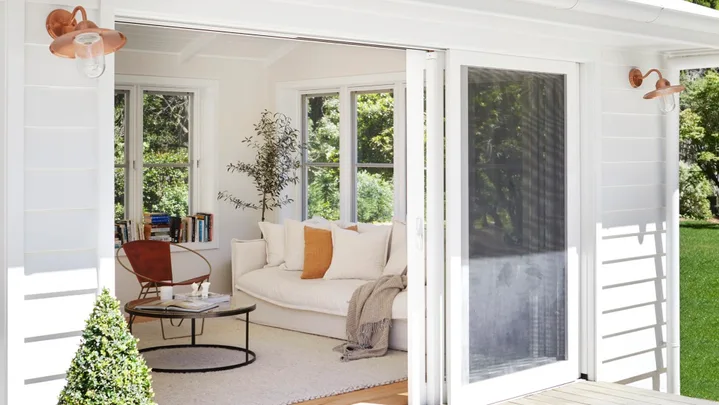 White multigenerational house with deck and gold wall lights