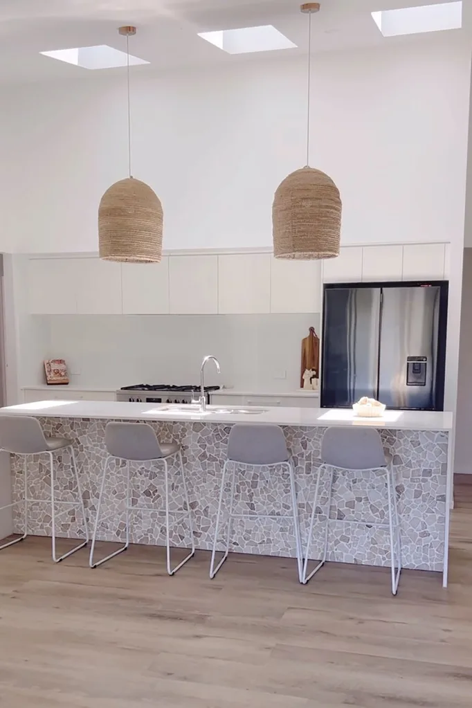 White kitchen with island tiled with Kmart's stone decking tiles