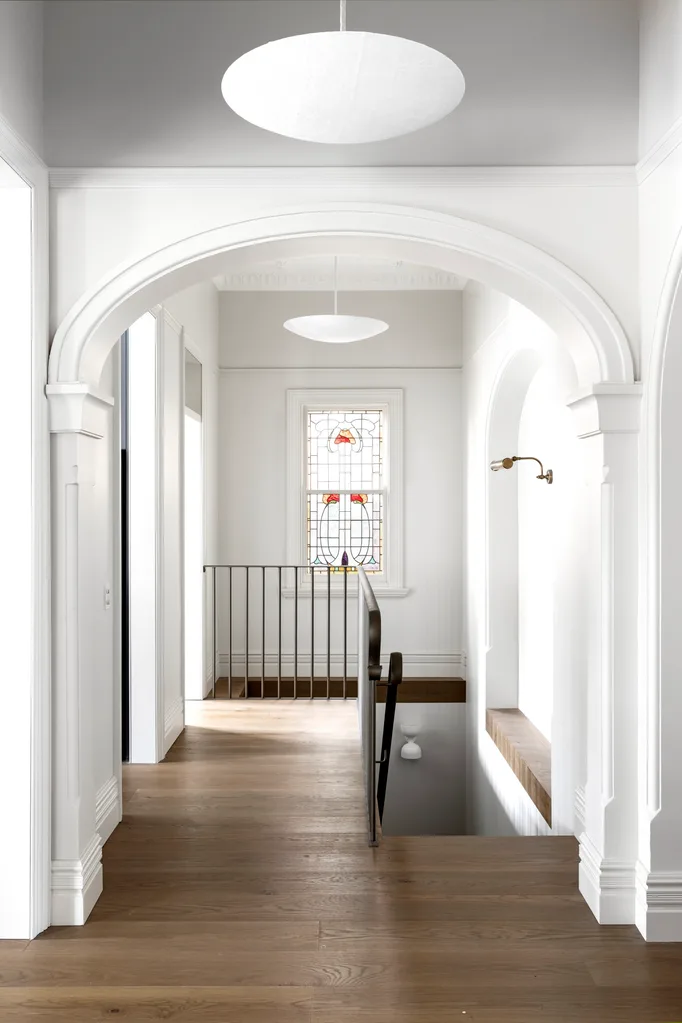 staircase with leadlight windows and black railing