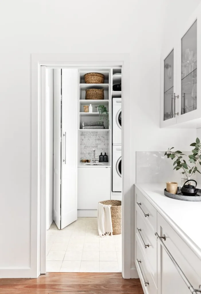 White laundry next to modern white kitchen